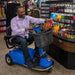 A man using the Amigo RD Scooter inside a store