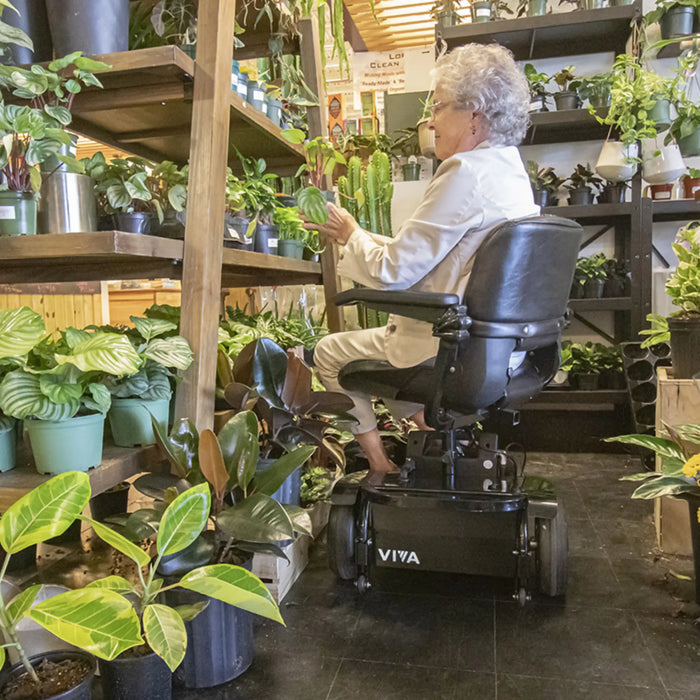 A woman riding the Amigo Viva Scooter checking her plants