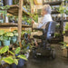 A woman riding the Amigo Viva Scooter checking her plants