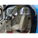 Interior of a small Gio Enclosed Mobility scooter vehicle with beige seats and dashboard.