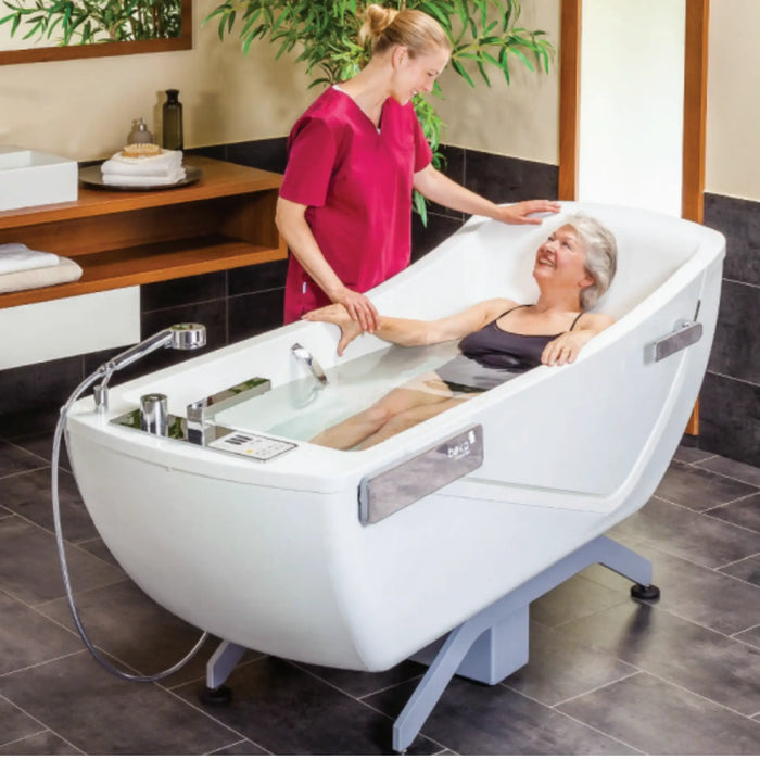 The Avero Motion Bath Tub by Handicare with user and caregiver