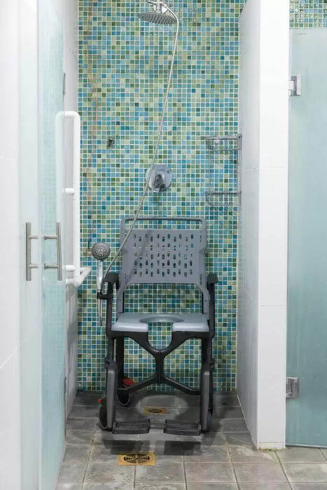 Shower with a disabled shower chair against a mosaic tiled wall. Seatara BathMobile in the Shower commode