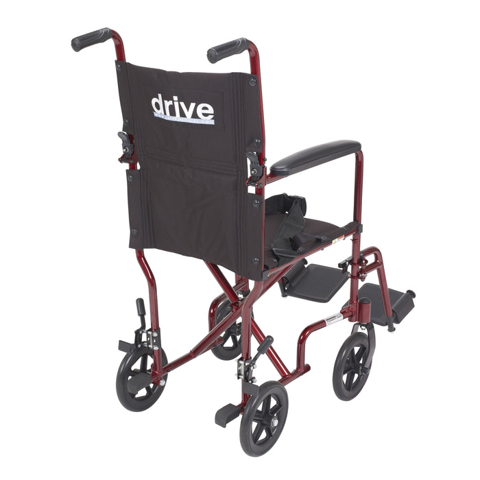 Rear three-quarter view of the red Drive Lightweight Transport Chair with folding back and Drive logo.