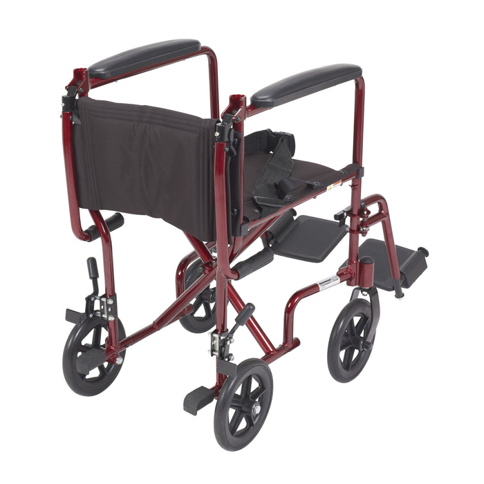 Red Drive transport chair from the rear with the folding back lowered, seat belt, wheel locks, and footrests.