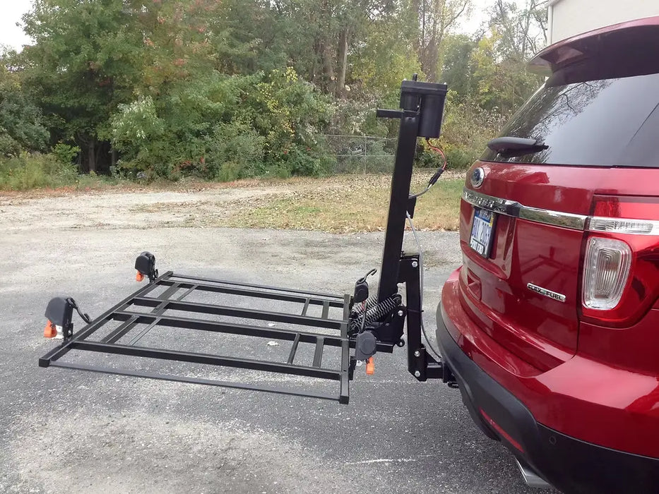 Wheelchair Carrier XL4 hitch-mounted scooter lift lowered behind SUV