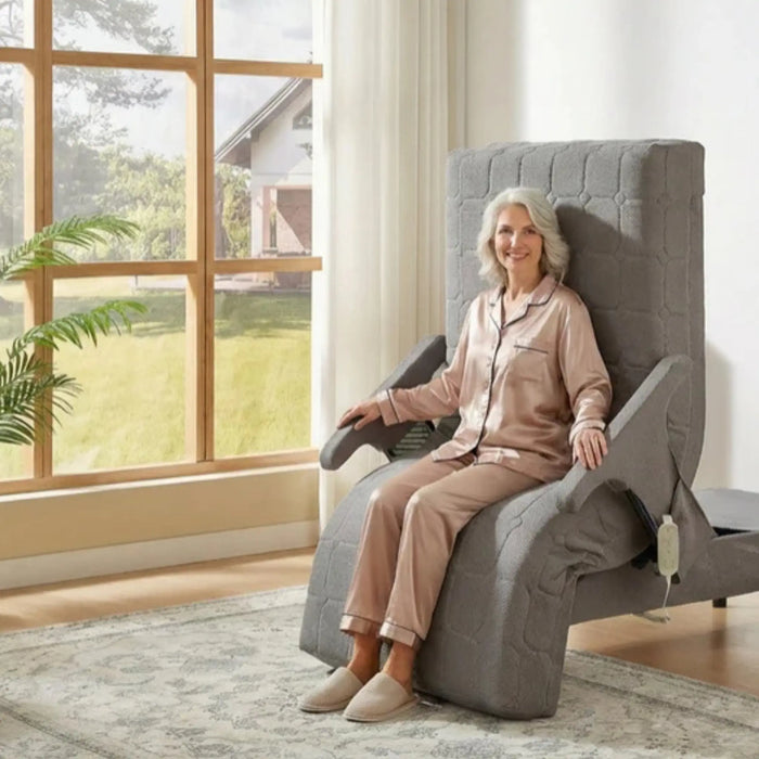 Senior woman seated comfortably in the EZLift Bed™ Deluxe Sleep To Stand Bed in Stand Assistance Position, demonstrating safe and supported transfers from bed to standing with integrated armrests and powered lift functionality.
