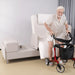Older adult transferring from the EZLift Bed Elevra Rotating Adjustable Bed to a rollator walker, demonstrating enhanced independence and mobility support.