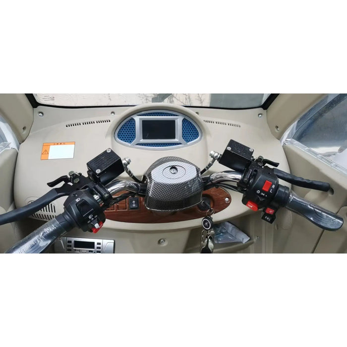 Close-up dashboard and handlebar controls inside the GIO Enclosed Mobility Scooter with digital display, ignition key, and driving controls.
