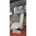 Side interior view of the GIO Enclosed Mobility Scooter showing padded driver seat with headrest, enclosed cabin door, manual window crank, and spacious weather-protected interior.