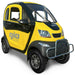 Yellow and black GIO Enclosed Mobility Scooter with enclosed weather-protected cabin, front bumper guard, and compact electric mobility vehicle styling.