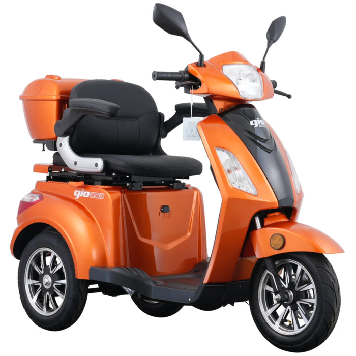 Studio view of the orange GIO Regal 3-Wheel Mobility Scooter with windshield, featuring a modern body design, comfortable seating, rear storage box, and stable three-wheel mobility platform.