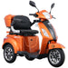 Studio view of the orange GIO Regal 3-Wheel Mobility Scooter with windshield, featuring a modern body design, comfortable seating, rear storage box, and stable three-wheel mobility platform.