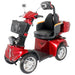 Front angled view of red GIO Tron Pro 4-Wheeled Smart Mobility Scooter highlighting LED headlight, mirrors, front basket, and padded captain seat.