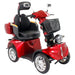 Three-quarter front view of the red GIO Tron Pro 4-Wheeled Smart Mobility Scooter with ergonomic seat, front basket, suspension column, and alloy-style wheels.