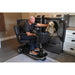 Man using a Amio HD mobility scooter to open a dryer with a dog inside. 