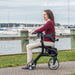 Nitro Sprint Rollator Rolling Walker, Black with a woman sitting on it