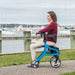 Nitro Sprint Rollator, Blue, side view with a woman sitting on it