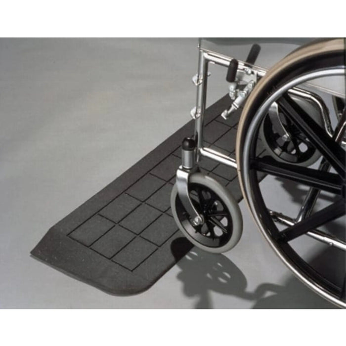 Wheelchair rolling over PVI rubber threshold ramp for smoother access across a raised doorway edge