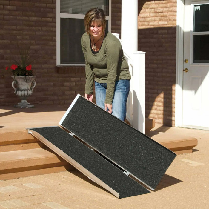 PVI singlefold threshold ramp being folded and positioned on outdoor steps for entry access