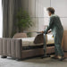User moving the StarSleep Motion Bed-Side Table alongside an adjustable bed, demonstrating smooth mobility, easy positioning, and convenient access for everyday bedside activities.